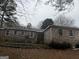 Exterior view of brick home featuring multiple windows and mature landscaping at 676 Bralorne Dr, Stone Mountain, GA 30087