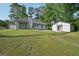 Rear exterior view of home with an outbuilding, lush lawn, and abundant natural light from windows at 2768 Southpark Sw Blvd, Conyers, GA 30094