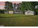 Rear exterior view of home with an outbuilding, lush lawn, and abundant natural light from large windows at 2768 Southpark Sw Blvd, Conyers, GA 30094