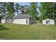 View of the rear of a home with a shed, a lush green lawn, a sidewalk, and a screened-in porch at 2768 Southpark Sw Blvd, Conyers, GA 30094
