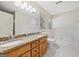Bathroom featuring granite countertop double sink vanity and white tiled tub at 2768 Southpark Sw Blvd, Conyers, GA 30094