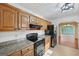 Kitchen with wooden cabinets, granite countertops, and black appliances at 2768 Southpark Sw Blvd, Conyers, GA 30094