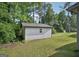 A backyard shed with a lush green lawn, a sidewalk, and trees at 2768 Southpark Sw Blvd, Conyers, GA 30094