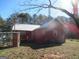 Back view of a red wood siding home with backyard and trees at 526 Mount Carmel Church Rd, Temple, GA 30179