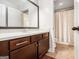 Well-lit bathroom with a large vanity, mirror, tile flooring and a shower behind a decorative curtain at 6 Water Oak Dr, Sharpsburg, GA 30277