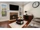 Inviting living room showcases a stone fireplace, a large TV, and ample natural light from the windows at 6 Water Oak Dr, Sharpsburg, GA 30277