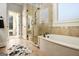 Luxurious main bathroom with a soaking tub, glass-enclosed shower, and stylish tile flooring at 6 Water Oak Dr, Sharpsburg, GA 30277
