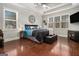 Spacious main bedroom with hardwood floors, tray ceilings, large windows, and a cozy seating area at 6 Water Oak Dr, Sharpsburg, GA 30277