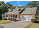 Beautiful single-story home with brick and a two-car garage, set amongst green trees at 225 Chinns Way, Hampton, GA 30228