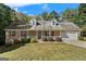 Charming brick home featuring an attached garage and inviting front porch at 225 Chinns Way, Hampton, GA 30228