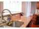 Close up on a kitchen sink with granite countertops and modern faucet, overlooking the dining room at 956 Shadowford Fls, Lithonia, GA 30058