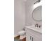 Modern powder room featuring white vanity with contrasting black hardware and round mirror at 118 Via Roma, Woodstock, GA 30188