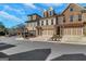 Modern townhomes featuring brick and stone exteriors with attached garages and manicured landscaping at 118 Via Roma, Woodstock, GA 30188