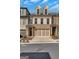 Beautiful brick townhome with a two car garage, manicured landscaping, and a walkway to the front door at 118 Via Roma, Woodstock, GA 30188