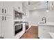 Modern kitchen with stainless steel appliances, white cabinets, hardwood floors, and a breakfast bar at 118 Via Roma, Woodstock, GA 30188