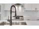 Close up of kitchen showcasing quartz counters, modern faucet and stainless cooktop at 118 Via Roma, Woodstock, GA 30188