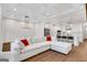 Bright living room with hardwood floors and a large white sofa with access to the kitchen at 118 Via Roma, Woodstock, GA 30188