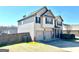 Side view of the home with a spacious two-car garage and well-kept lawn at 611 Winners Cir, Locust Grove, GA 30248