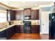 Modern kitchen with granite countertops, dark wood cabinets, and hardwood floors at 611 Winners Cir, Locust Grove, GA 30248