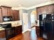 Well-equipped kitchen with dark wood cabinets, granite countertops, and stainless steel appliances at 611 Winners Cir, Locust Grove, GA 30248