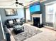 Inviting living room with plush rug, dark leather sofas, fireplace, neutral color palette, and large screen TV at 611 Winners Cir, Locust Grove, GA 30248