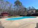 Community pool with light blue water and a concrete deck surrounded by mature trees and landscaping at 104 Summer Chase, Carrollton, GA 30116