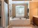 Relaxing main bathroom with a large soaking tub, window, and tiled shower at 8179 Pineview Ct, Villa Rica, GA 30180