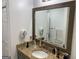 Bathroom with granite countertops, undermount sink, framed mirror, and wall-mounted hair dryers at 281 Timber Laurel Ln, Lawrenceville, GA 30043