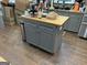 Kitchen island with gray cabinetry, stainless steel trash can, and butcher block countertop at 281 Timber Laurel Ln, Lawrenceville, GA 30043