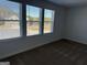 An empty bedroom with carpet floors and plenty of natural light from the three bright windows at 1224 Hibiscus Way, Mcdonough, GA 30253