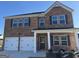 Charming two-story brick home featuring a two-car garage, dark shutters and a covered front porch at 1224 Hibiscus Way, Mcdonough, GA 30253