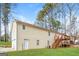 Back exterior view of house, highlighting the deck, lawn, and entrance to basement at 117 Parkway Ct, Dallas, GA 30157