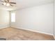 Bright bedroom features neutral walls, carpeted floors, a ceiling fan, and a window at 117 Parkway Ct, Dallas, GA 30157