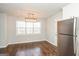 Dining area featuring hardwood floors, a modern light fixture, and a stainless steel refrigerator at 117 Parkway Ct, Dallas, GA 30157