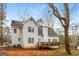 View of back of home with wooden deck in the backyard with trees at 495 N Oakland Cir, Mcdonough, GA 30253
