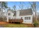 View of back of home with wooden deck in the backyard with trees and some grass at 495 N Oakland Cir, Mcdonough, GA 30253