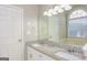 Bright bathroom featuring a double vanity with granite countertop, a large mirror, and a arched window over a tub at 495 N Oakland Cir, Mcdonough, GA 30253