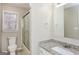 Bright bathroom featuring a single vanity with granite countertop, a large mirror, and a glass enclosed shower at 495 N Oakland Cir, Mcdonough, GA 30253