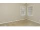 Neutral bedroom with carpet and two windows looking out onto trees at 495 N Oakland Cir, Mcdonough, GA 30253