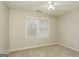 Neutral bedroom with carpet, a ceiling fan, and window looking out onto trees at 495 N Oakland Cir, Mcdonough, GA 30253