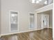 Inviting living room featuring tall ceilings, neutral walls, two big windows, and hardwood floors at 495 N Oakland Cir, Mcdonough, GA 30253
