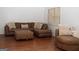 Comfortable living room featuring plush sectional sofa, ottoman, and hardwood flooring at 1630 Versailles Sw Dr, Atlanta, GA 30331