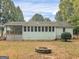 The house's back exterior with a sunroom, a firepit and a big back yard at 220 Melrose Way, Mcdonough, GA 30252
