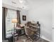 Light-filled bedroom featuring a window and a desk with a lamp and a chair at 220 Melrose Way, Mcdonough, GA 30252