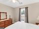 Comfortable bedroom offers natural light from a window with backyard view at 220 Melrose Way, Mcdonough, GA 30252