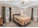 Spacious main bedroom with tray ceiling, ceiling fan, and windows with backyard view at 220 Melrose Way, Mcdonough, GA 30252