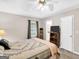 Cozy main bedroom includes ceiling fan and view into the main bathroom at 220 Melrose Way, Mcdonough, GA 30252