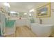 Sun-filled bathroom featuring a soaking tub, decorative mirrors, and wood-look flooring at 170 Majesty Ln, Fayetteville, GA 30215
