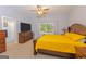 Bedroom with carpet, wooden furniture, yellow bedspread, ceiling fan, and large window at 170 Majesty Ln, Fayetteville, GA 30215
