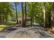 Gravel driveway leading to a house nestled among tall trees and lush greenery at 170 Majesty Ln, Fayetteville, GA 30215